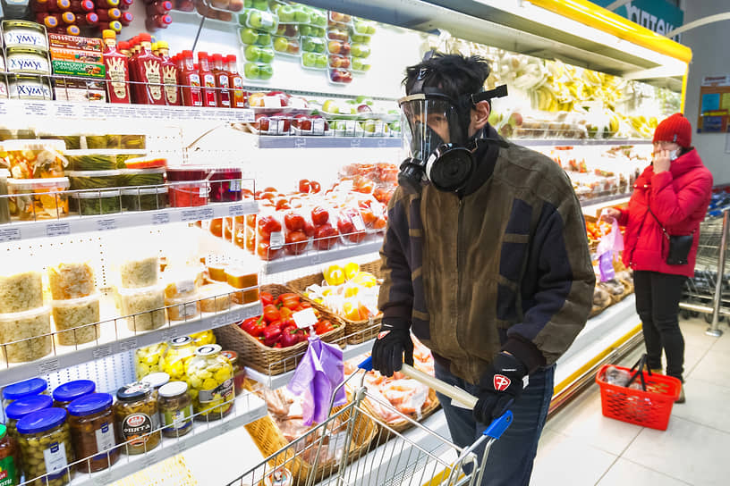 Молодой человек покупает продукты в респираторе в новосибирском Академгородке