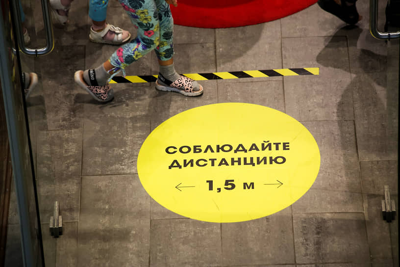 Новосибирск после смягчения карантинных мер из-за COVID-19. Маркировка «Соблюдайте дистанцию» на полу магазина