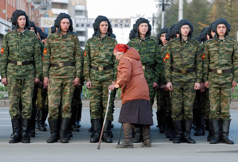 Пожилая женщина проходит вдоль строя военнослужащих во время репетиции Парада Победы в Барнауле в 2009 году