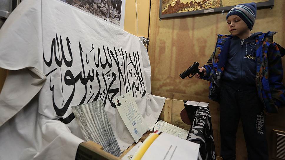 Юный пермяк рассматривает плакат сирийских боевиков.