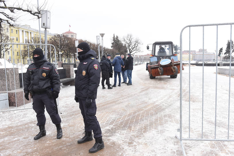 Сотрудники полиции во время охраны площади, на которой коммунальные службы проводят уборку