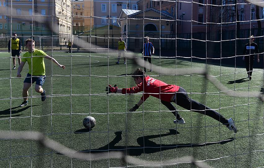 Подростки играют в футбол на спортивной площадке в Юсуповском парке