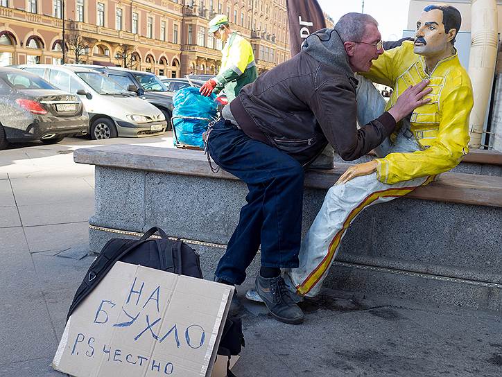 Веселый мужчина обнимает пластиковую фигуру музыканта Фредди Меркьюри на Невском проспекте