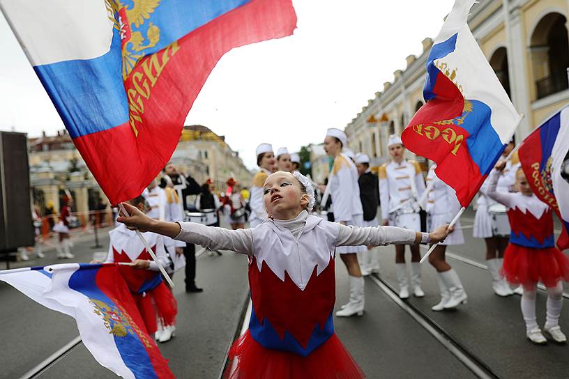 Девочка с флагами РФ на Садовой улице во время парада посвященного Дню города