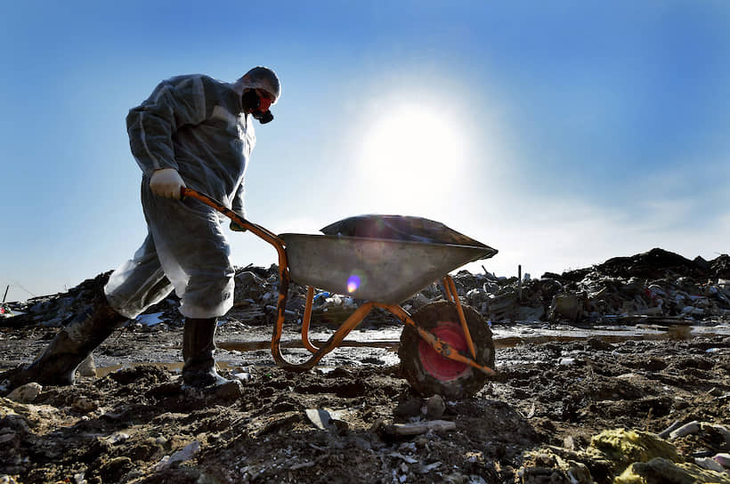 Сотрудник компании ГУП &quot;Экострой&quot; во время работ по утилизации опасных отходов и мусора на несанкционированной свалке во Всеволожском районе Ленинградской области