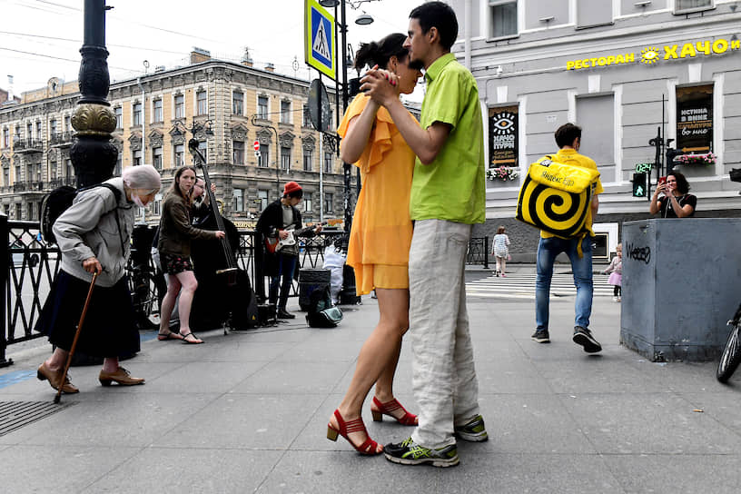 Молодые люди танцуют под музыку уличных музыкантов на улице Рубинштейна во время режима рекомендованной самоизоляции из-за опасности распространения коронавирусной инфекции COVID-19