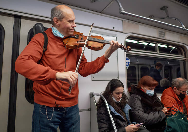 Мужчина играет на скрипке в вагоне метро