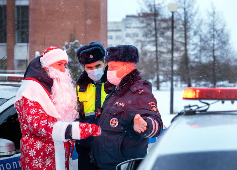 Участник благотворительного автопробега в костюме Деда Мороза общается с сотрудниками ДПС