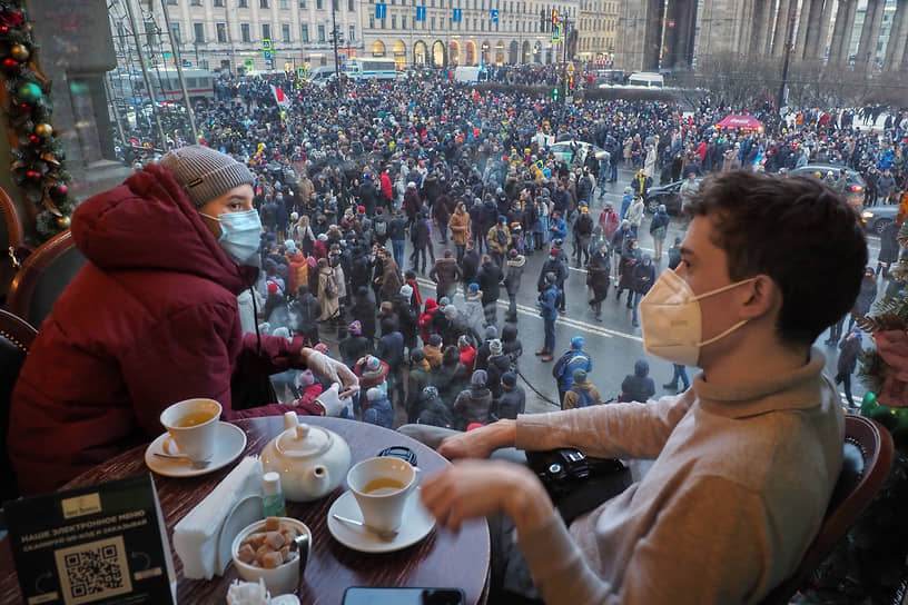 Несогласованные акции в поддержку политика Алексея Навального в центре Петербурга. Посетители кафе наблюдают за маршем протестующих на Невском проспекте
