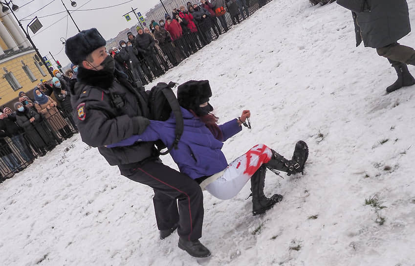 Несогласованная акция в поддержку политика Алексея Навального на Сенатской площади. Сотрудник полиции во время задержания девушки