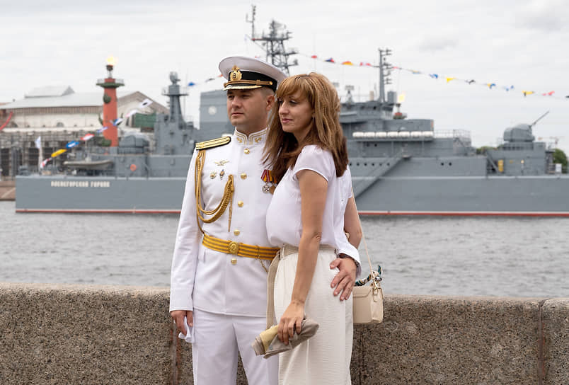Празднование Дня Военно-морского флота (ВМФ) России. Молодые люди на набережной на фоне военного корабля