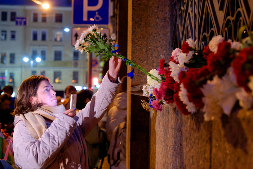 Женщина возлагает цветы в ограждение Большой Хоральной Синагоги