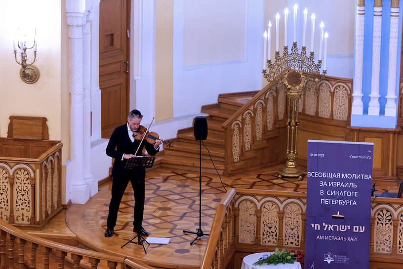 Музыкант играет на скрипке перед началом молитвы