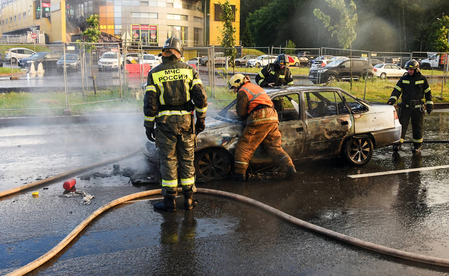 Пожарные во время тушения автомобиля после ДТП в Приморском районе