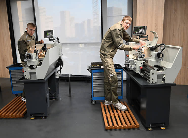 Учащиеся колледжа во время работы на токарном станке