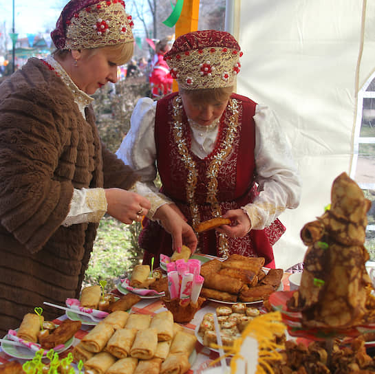 Празднование &quot;Широкой Масленицы&quot; в станице Старочеркасская. Женщины раскладывают блины с начинкой.