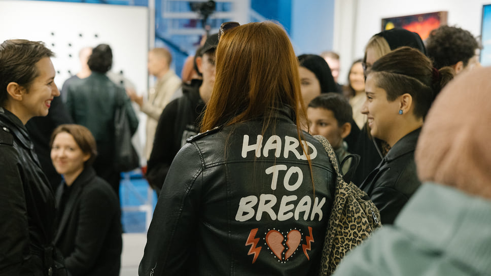 Посетительница выставки с надписью Hard to Break на куртке