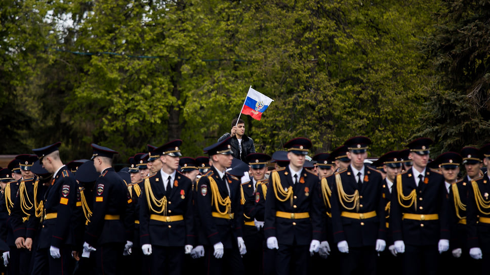 Уфимец с флагом России на фоне военных