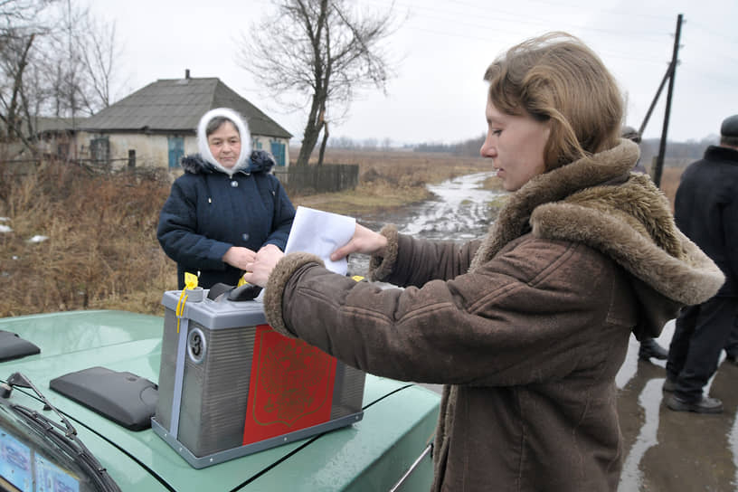 Президентские выборы в Подгоренском районе. Женщина опускает бюллетень в переносную урну для голосования. Март, 2008 год
