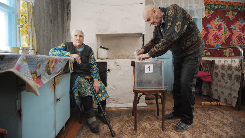 Житель поселка Новая Жизнь Грибановского района опускает бюллетень в переносную урну для голосования. 2012 год
