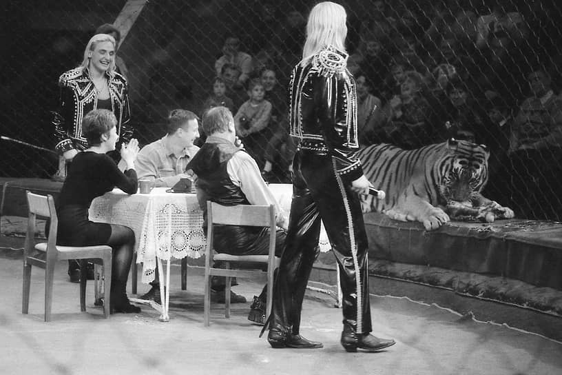 Аскольд Запашный (крайний слева) и Эдгард Запашный (крайний справа) в воронежском цирке во время представления с номером, в котором зрители пьют чай в клетке с тигром