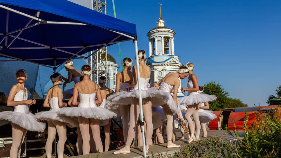 Балерины в пачках готовятся подняться на сцену, установленную на Советской площади 