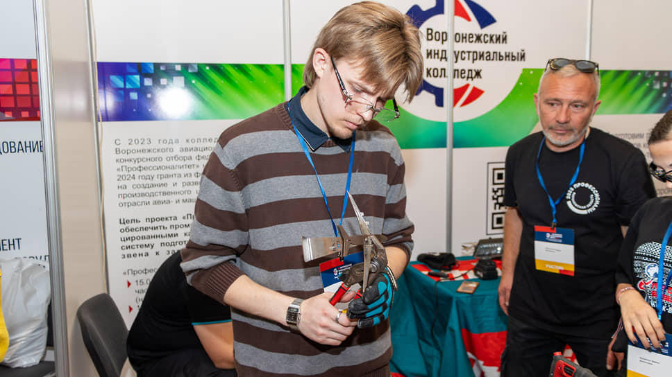 Экспозиция XV Воронежского промышленного форума. Студент Воронежского индустриального колледжа изготавливает металлическую модель самолета