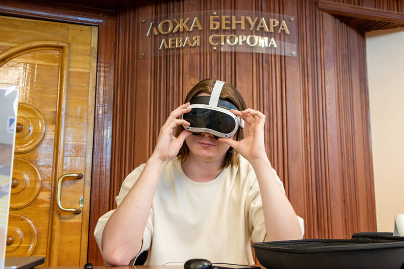 Посетитель тестирует очки виртуальной реальности на интерактивной площадке форума