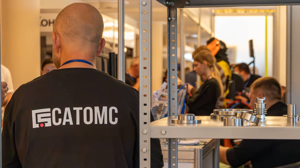 Представитель компании «Сатомс» у фирменного стенда форума