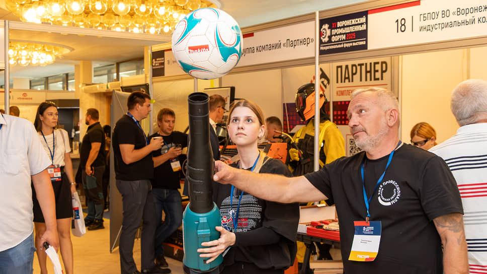 Экспозиция XV Воронежского промышленного форума. На стенде компании «Сатомс» девушка демонстрирует возможности воздуходува, подбрасывая футбольный мяч
