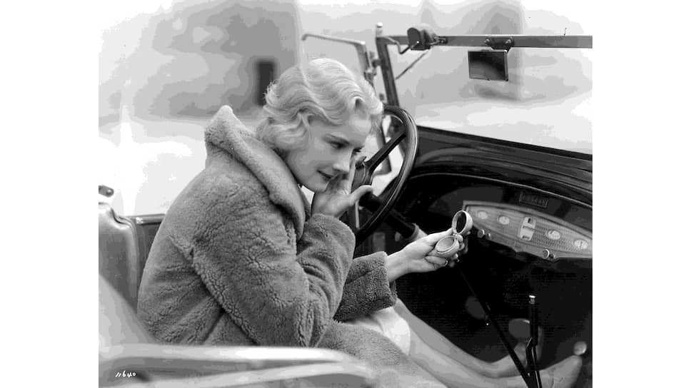 Американская кинозвезда Жозефина Данн поправляет макияж за рулем своей машины, 1928 год