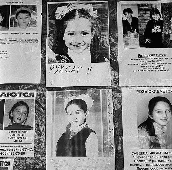 Фотографии без вести пропавших на стене у входа в школу 