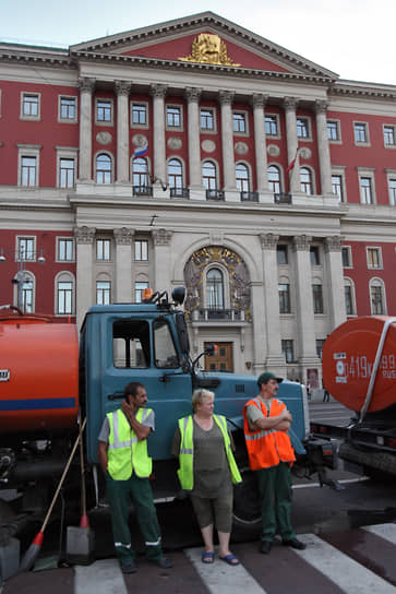 Работники коммунальной службы возле здания московской мэрии