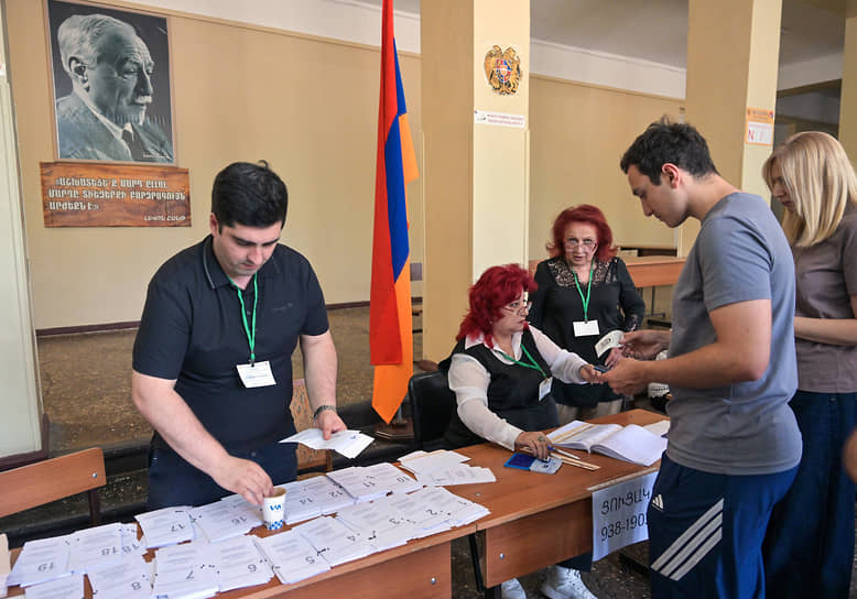 Избиратели получают бюллетени на участке
