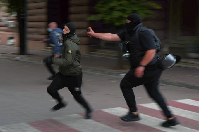 Полицейский применяет перцовый баллончик в ходе антиправительственных протестов