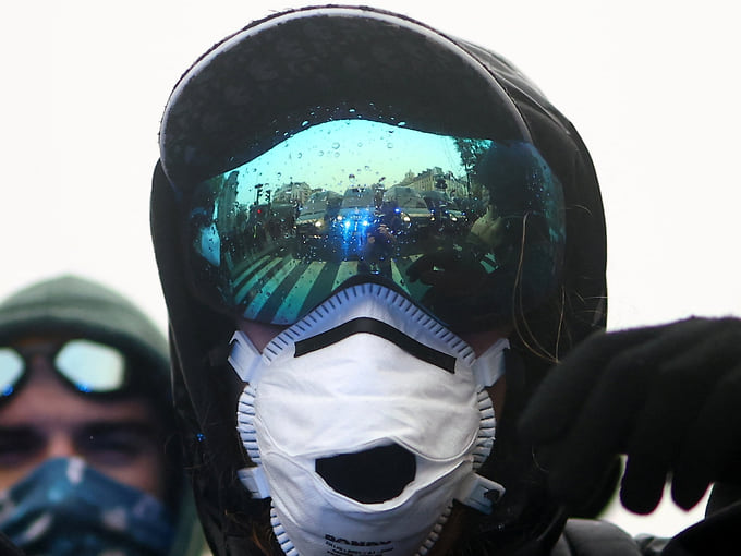 Полицейские отражаются в защитных очках участника акции