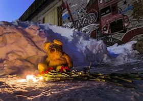 Игрушка и цветы на месте обрушения крыши на гаражной вечеринке в Новосибирске. Под завалом погибла девушка