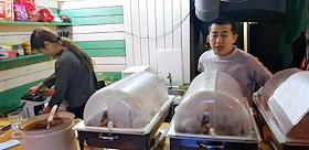 Повар и буфетчица за прилавком маленького китайского кафе 'для своих'