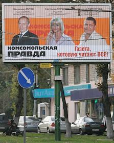 Рекламный щит газеты 'Комсомольская правда' с портретами В.Путина, Н.Расторгуева и С.Хоркиной