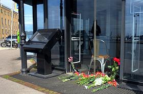 Цветы возле входа у кафе 'Патриот' на Университетской набережной в Санкт-Петербурге, которое связывают с основателем ЧВК 'Вагнер' Евгением Пригожиным. Памятник Трезини на фоне отеля 'Трезини', который связывают с Евгением Пригожиным