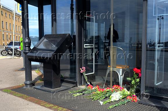 Цветы возле входа у кафе 'Патриот' на Университетской набережной в Санкт-Петербурге, которое связывают с основателем ЧВК 'Вагнер' Евгением Пригожиным. Памятник Трезини на фоне отеля 'Трезини', который связывают с Евгением Пригожиным