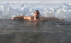 Любители закаливания и зимнего плавания во время купания в проруби на озере 'Блюдце' в Новосибирске при температуре около -35 градусов