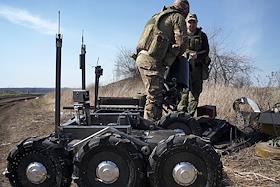 Бойцы подразделения имени Михаила Архангела тестируют на полигоне штурмовых роботов, оснащенных модулем для сброса мин и модулем для установки пулемета