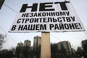 Корреспондент ИД 'КомерсантЪ' Никита Аронов с плакатом 'Нет незаконному строительству в нашем районе'