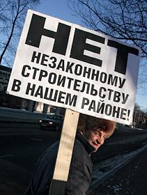 Корреспондент ИД 'КомерсантЪ' Никита Аронов с плакатом 'Нет незаконному строительству в нашем районе'