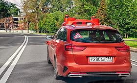 Жанровые фотографии. Автомобиль со знаком, обозначающим автономное управление транспортным средством и установленными системами контроля окружающей среды для автономного вождения