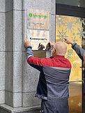 Genre photography. Installation of a Kommersant JSC sign at the entrance to the Oruzheyny business center