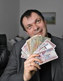 Глава страховой компании 'Отечество' Павел Иванушко с коллекцией денежных купюр в офисе