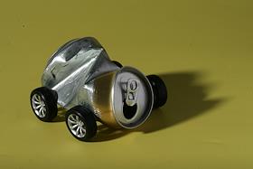 Обложка. Мятая жестяная банка из-под напитков на колесиках