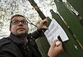 Корреспондент журнала 'Деньги' ИД 'КоммерсантЪ' Ждакаев Иван наклеивает рекламное объявление